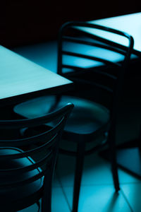 Empty chairs by table in darkroom