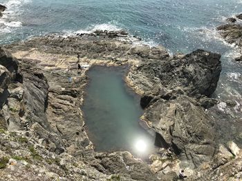 High angle view of people on rocks by sea