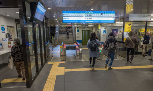 Rear view of woman standing on illuminated walkway