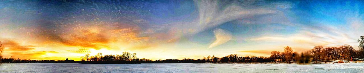 Snow covered field at sunset