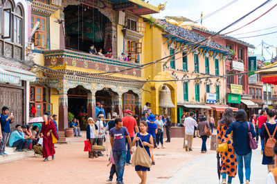 People walking on street against buildings in city