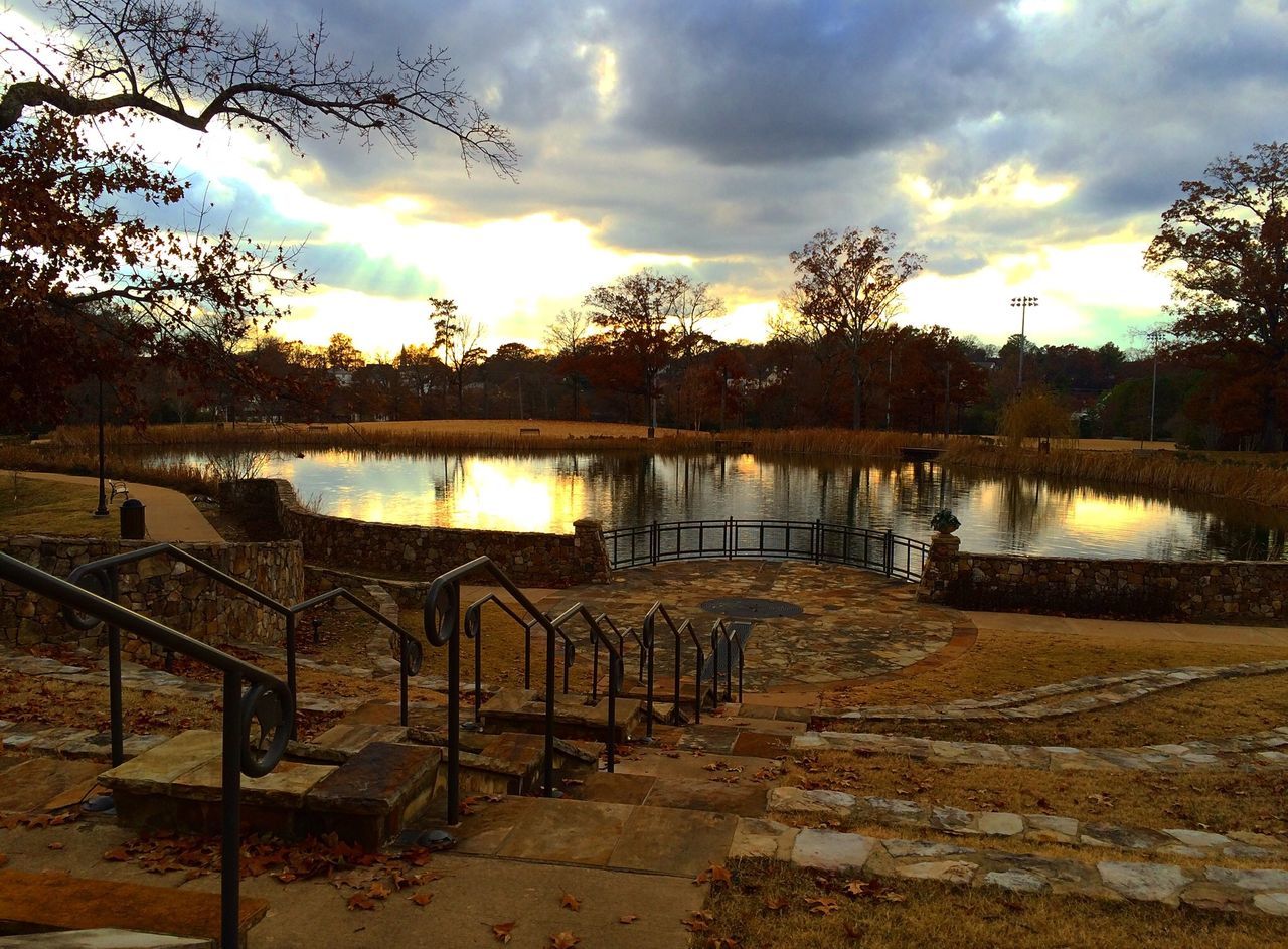 sunset, sky, water, tree, cloud - sky, tranquility, tranquil scene, railing, lake, nature, scenics, beauty in nature, reflection, sun, sunlight, river, idyllic, cloudy, empty, cloud