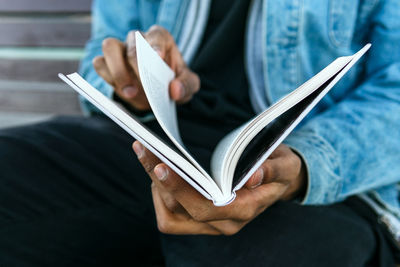 Midsection of man holding paper