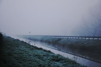 Scenic view of river against clear sky during winter