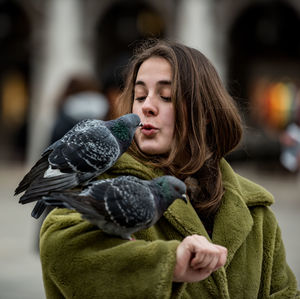 Close-up of young woman with bird
