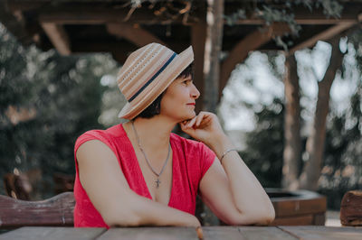 Mature woman looking away while sitting at table