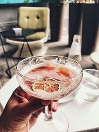 Close-up of hand holding drink on table