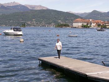 Full length of woman standing on jetty over river