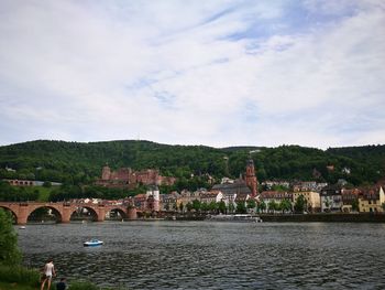 Lake with bridge and church against sky