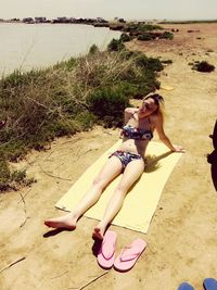 Rear view of woman sitting on beach