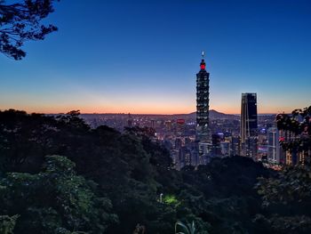 Illuminated buildings in city against sky
