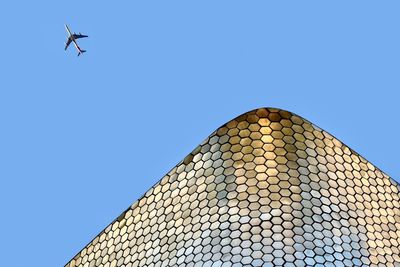 Low angle view of airplane flying against clear sky