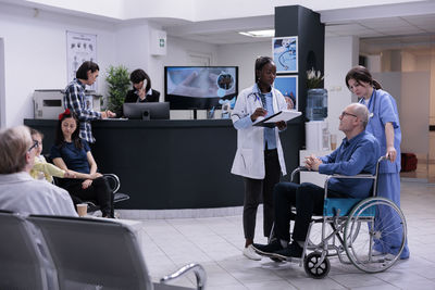 Doctor consulting with patient on wheelchair in hospital