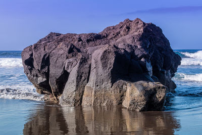 Rock formation in sea against sky