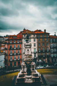 Buildings against cloudy sky in city