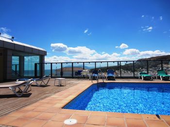 Private roof top blue beautiful swimming pool area with sun beds relax on holiday in spain europe 