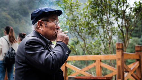 Side view of man smoking cigarette