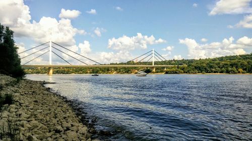 Suspension bridge over river against sky