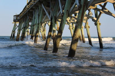 Scenic view of pier on beach against sky