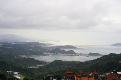 High angle view of townscape by mountains against sky