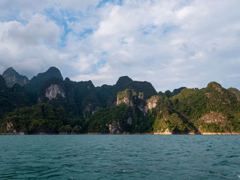 Scenic view of sea and mountains against sky