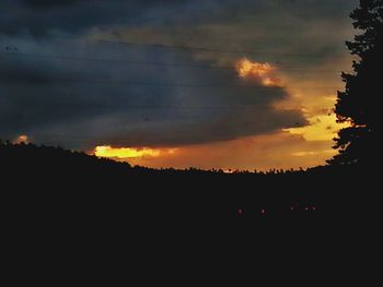 Silhouette of landscape against cloudy sky