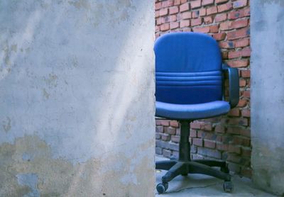 Close-up of chair against blue wall