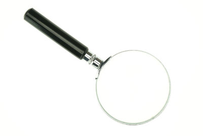 Close-up of magnifying glass on white background