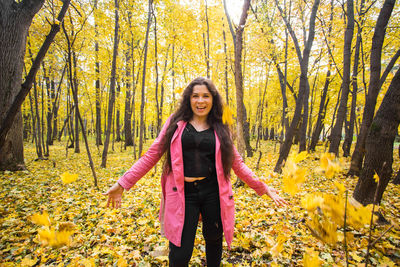 Young woman standing in forest during autumn