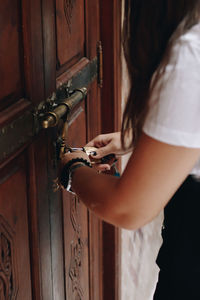 Midsection of woman locking a door 