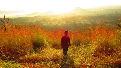 Rear view of woman standing on grassy field