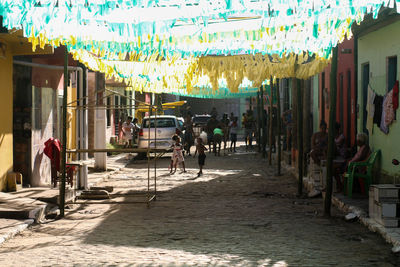 People on street amidst buildings in city