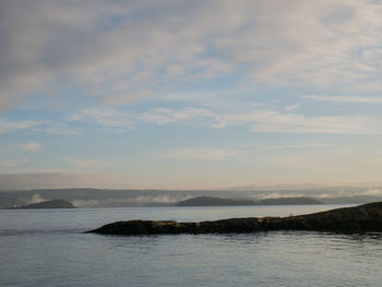 Scenic view of sea and mountains against sky