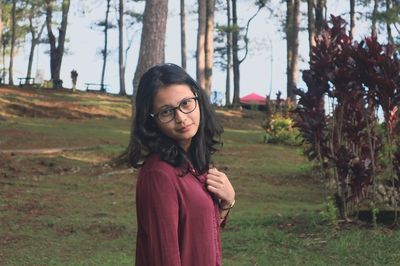 Portrait of young woman standing at field