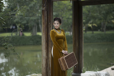 Portrait of smiling young woman standing in water