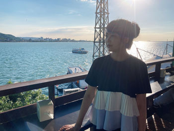 Woman looking at sea against sky