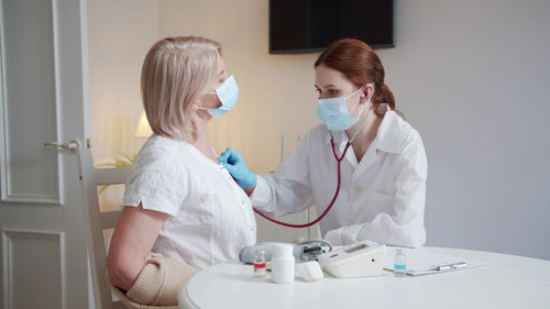 Female doctor examining patient at clinic