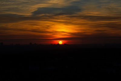 Scenic view of silhouette landscape against orange sky