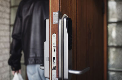 Close-up of modern lock on door with senior man in background