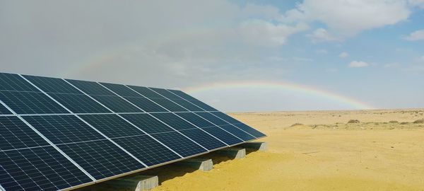 Solar panels on field against sky