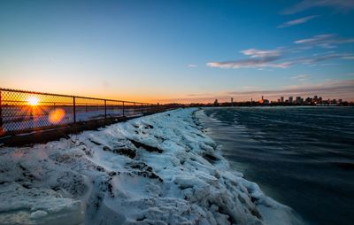 Scenic view of frozen river against sky during winter