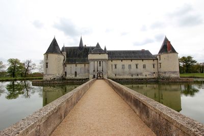 River by historic building against sky