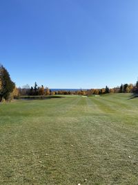 Scenic view of field against clear blue sky