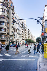 People walking on road along buildings