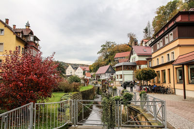 Canal amidst buildings in town against sky