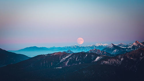 Scenic view of snowcapped mountains against sky during sunset