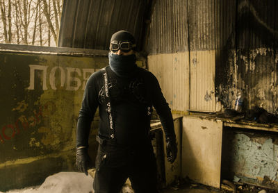 Man face covered with mask in abandoned room