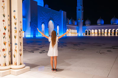 Rear view of woman standing at night