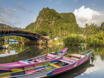 Boats moored in lake against sky