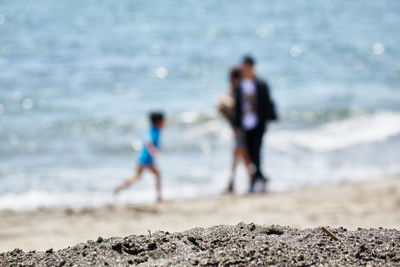 Rear view of couple standing at beach